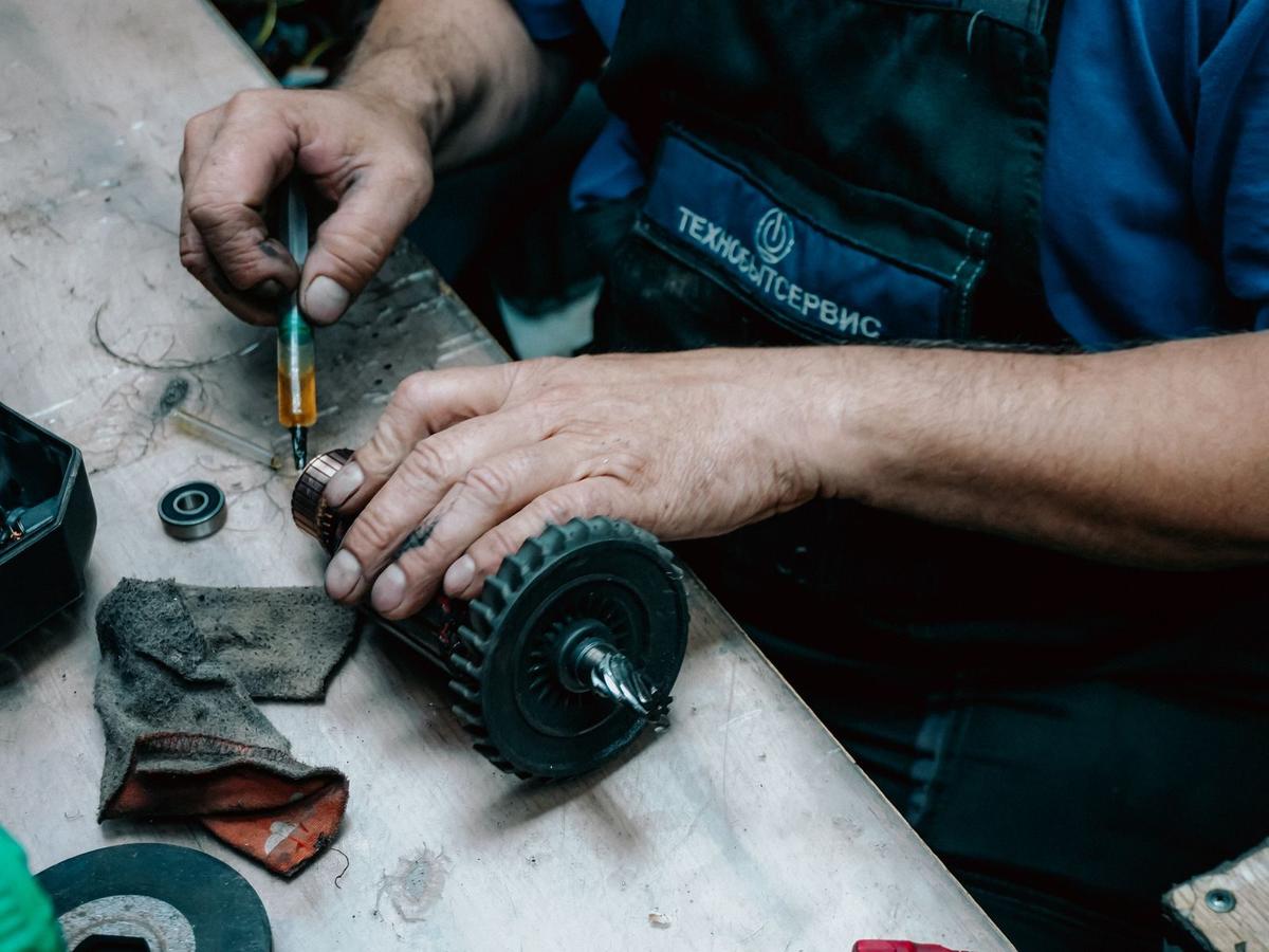 Dłonie mechanika przy rozebranym silniku